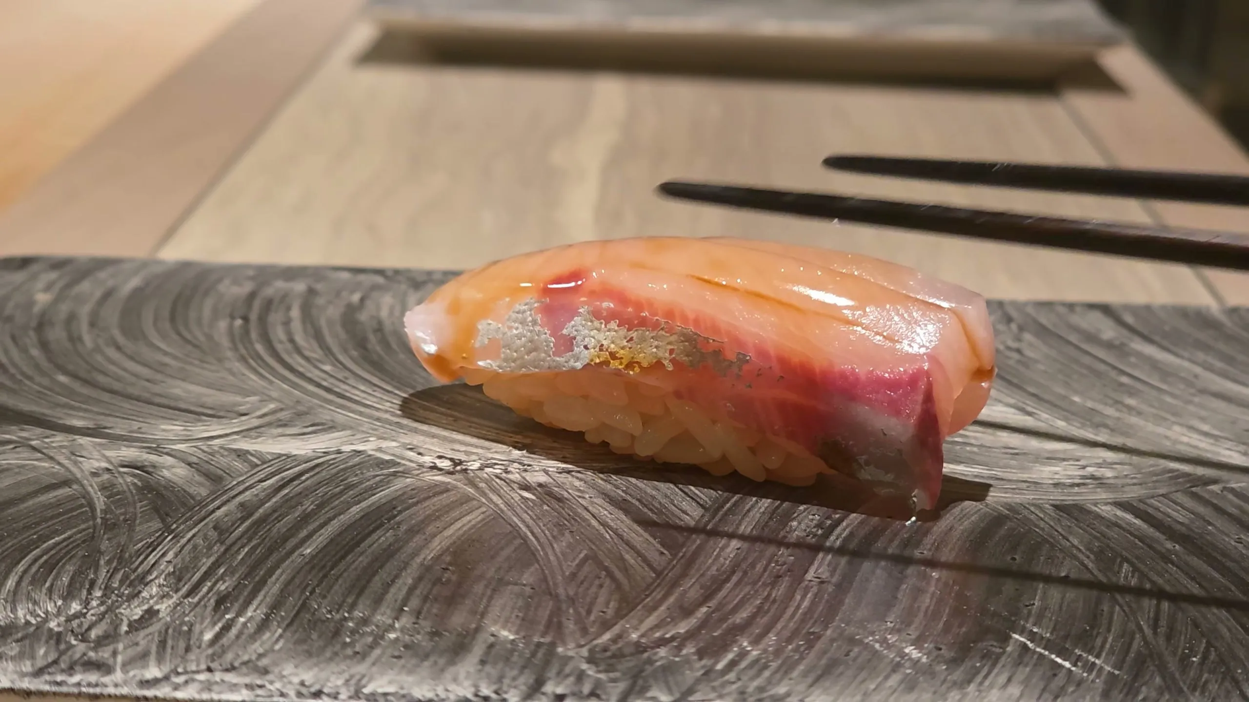Shima-aji nigiri on a brushed slate plate
